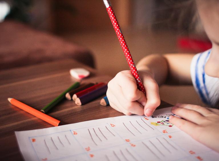 A young child colours in.