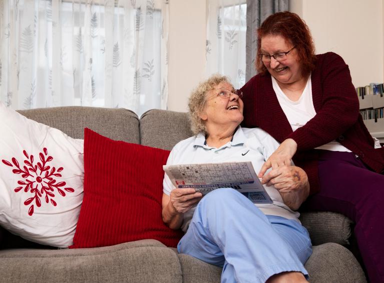 An older same-sex couple read together.