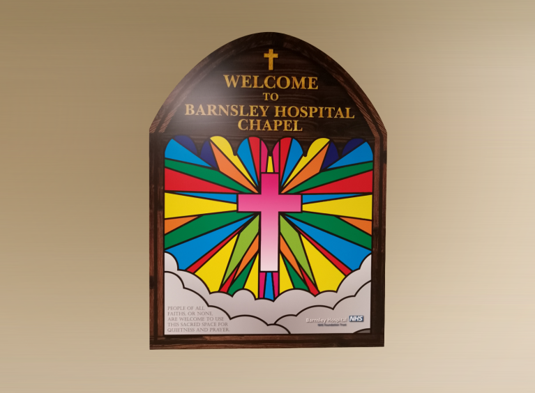 The Hospital Chapel sign hangs on the wall outside the Chapel