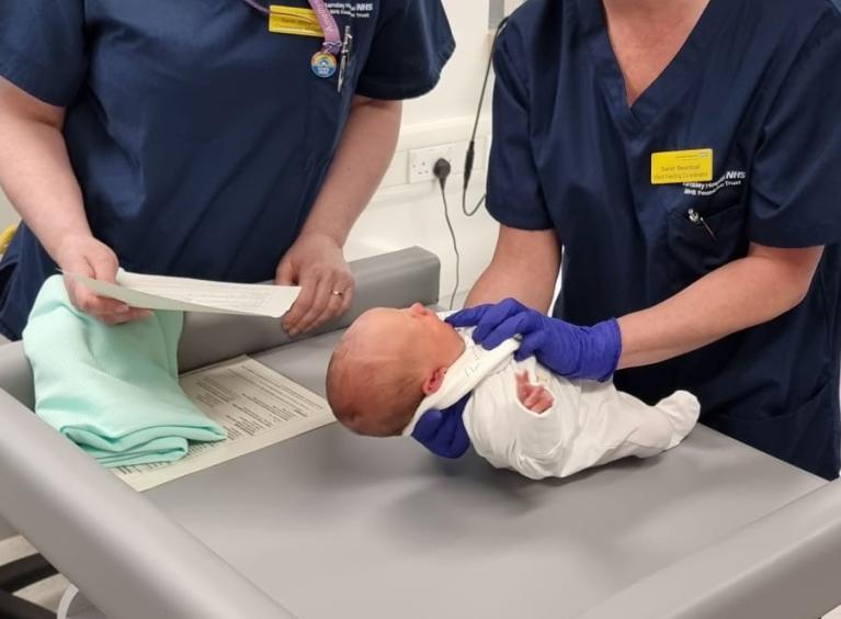 Staff and baby in tongue-tie clinic