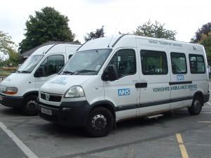 Two white mini-buses used for patient transport, to and from Barnsley Hospital - the NHS logo and Yorkshire Ambulance Service is written on the buses