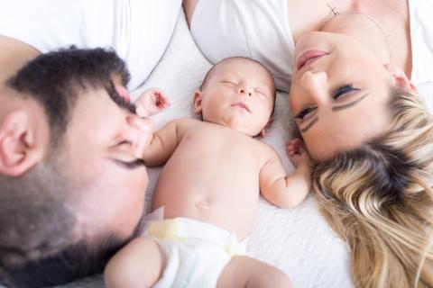 Parents on bed with baby