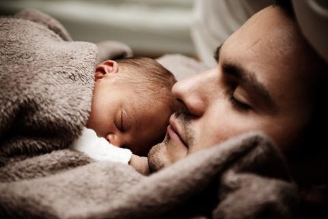 Father holds sleeping baby on his chest