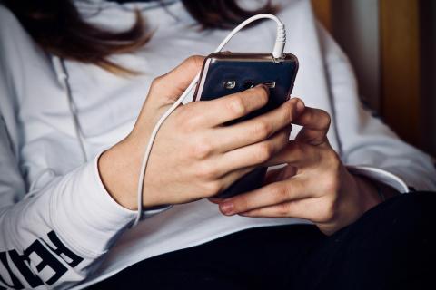 A woman using a smartphone with headphones