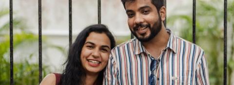 A young couple smile, looking at the camera