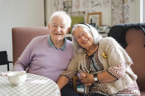 An older couple smile and look at the camera together